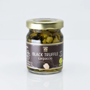 A glass jar with a gold lid labeled Taycte Black Truffle Carpaccio by Taycte, containing sliced Tuber Aestivum (black truffles). The label features images of truffles along with vegan and gluten-free symbols.