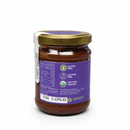 A glass jar with a gold lid, filled with a vibrant red sauce. The purple label for Taycte Taycte Organic Hazelnut Cocoa Cream by Taycte highlights its gluten-free, lactose-free, and certified organic attributes. Recycling symbols are displayed at the bottom. While the sophisticated packaging is similar to that of an organic hazelnut cocoa cream or chocolate spread, this product distinguishes itself with its striking color and allergy-friendly features.