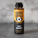 The Spice Witch Hot Honey & Chili Crisp Bundle features bold flavors, a striking yellow and black label with an eye graphic, and is crafted in Asheville, NC by a woman-owned business—perfect for fans of Hot Honey or Chili Crisp.