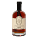 A clear glass bottle with a black cap contains Under The Bark Syrup Co Vanilla Maple Syrup. Its label states 100% Pure Maple Syrup, Vanilla, Made in Minnesota, and features the brand name Under The Bark Syrup Co.