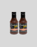 Two identical bottles of Gourmet Carolina Gold Hot Vinegar Pepper Carolina Gold BBQ Sauce with black caps and labels reading Hot Vinegar Pepper Sauce with Cayenne Peppers.
