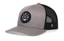 The Haka Hat Spokane Trucker Hat features a gray front, black mesh back, comfort-fit sweatband, and a round patch with crossed lines, "S" and "P," plus a white fish—bringing Spokane-inspired style from Haka Hat.