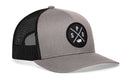 The Haka Hat Spokane Trucker Hat is a gray and black snapback with a mesh back, comfort-fit sweatband, and a round front patch displaying "SPO" plus a small fish or Spokane symbol.