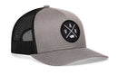 The Haka Hat Vancouver Trucker Hat is a gray and black comfort-fit snapback with a mesh back, featuring a circular VAN cross-patch and Vancouver, WA map outline on the front.