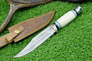 The Texan Knives Hand-Forged Western Boulder Colorado Knife features an 11” razor sharp Damascus blade, a resin grip handle, and comes with a brown leather sheath with yellow stitching and brass snap button.