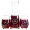 A Swanky Badger Wine Decanter - The Modern and two stemless glasses filled with red wine, each featuring custom engraved lettering of an M inside a geometric triangle design.