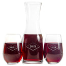 A Swanky Badger Wine Decanter - The Diamond set featuring a decanter and two stemless wine glasses filled with red wine, each engraved with a diamond-shaped frame containing the names Andrea, Smith, and Jason.