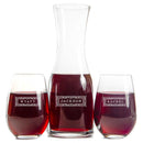 A Wine Decanter - The Classic set featuring a glass decanter and two stemless wine glasses filled with red wine, each engraved with a decorative border and the names Wyatt, Jackson, and Rachel.