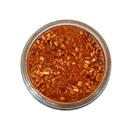 A glass jar of SALTOPIA Infused Sea Salts’ YACK-ety YACK, a reddish-brown, low sodium Southwestern seasoning blend with crushed dried ingredients, shown from above on a white background.