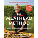 A man stands outdoors behind a grill holding a copy of The Meathead Method: A BBQ Hall of Famer’s Secrets and Science on Bbq, Grilling, and Outdoor Cooking with 114 Recipes, alongside a plate of meat and corn.