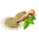 A wooden scoop with dried oregano spilling out sits next to two fresh, organic sweet basil leaves from The Spice Lab Organic Sweet Basil, all on a white background—perfect ingredients for Italian-inspired cooking.