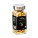 A glass jar of The Spice Lab Organic Pine Nuts, featuring a silver lid and a black label with the product name and weight (2.2 oz). The jar contains whole organic pine nuts from The Spice Lab—ideal for baking or as a salad topping.