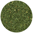 A close-up view of The Spice Lab Organic Parsley Flakes showcases finely chopped green leaves spread evenly within a circular frame—an essential choice among garnishing herbs from The Spice Lab.