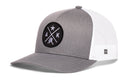 Grey and white Haka Hat Alaska Trucker Hat featuring a circular patch with crossed lines, a star, the letters A and K, and a small silhouette of Alaska.