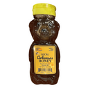 The Guenther Apiary Arkansas Wildflower Honey Bear is a plastic, bear-shaped bottle with a yellow cap, filled with local wildflower honey from Arkansas. Its label states “100% Raw Unfiltered” and “100% Pure Natural,” and notes that it is produced by Guenther Apiary in Roland, AR, with a net weight of 12 oz.