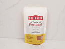 A white and yellow spice pouch labeled World Spice A Taste of Portugal rests on a white surface. Crafted by World Spice, the bag highlights salty, picante, and smoky flavors with notes of paprika and garlic to evoke classic Portuguese family recipes.