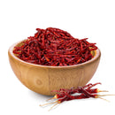 A wooden bowl brimming with Rico Rico Chile de Árbol Dried Chiles – Hot & Authentic Mexican Peppers, delivering that genuine Mexican heat, with a few extra peppers from Rico Rico arranged in front of the bowl—all displayed on a crisp white background.