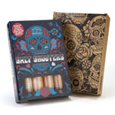A boxed gift set from The Spice Lab, labeled “Tequila Himalayan Salt Shooters Gift Set,” showcases vibrant sugar skull artwork and includes a window displaying distinctive Himalayan salt shot glasses—perfect for cocktail shooters. Next to it is another box decorated with bold black skull designs.