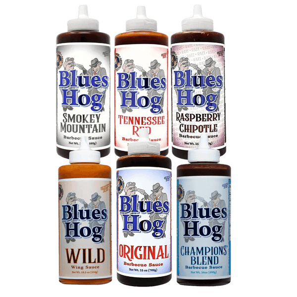 Six bottles of Blues Hog barbecue sauces are arranged in two rows. Flavors include Smokey Mountain, Tennessee Red, Raspberry Chipotle, Wild Wing Sauce, Original, and Champions’ Blend. Each bottle has a distinct color label.