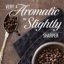 A spoon and bowl filled with The Spice Lab Special Extra Bold Indian Black Peppercorns sit on a dark cloth. Text reads: Very aromatic and slightly sharper.