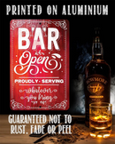 A red Bar Open, Proudly Serving Whatever You Bring - Metal Sign by Lone Star Art adds perfect bar decor that won’t rust, fade, or peel. Pictured with Bowmore whisky and a glass of whisky with ice.