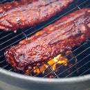 Barbecue ribs on a charcoal grill with flames below