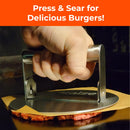 A hand presses the Braize Smash Burger Press with Folding Handle & 50 Non-Stick Paper Sheets onto ground beef on a griddle. White text on orange reads, "Press & Sear for Crispy-Edged Burgers!" Brand: Braize.