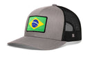 A Haka Hat Brazil Flag International Trucker Hat, this Brazilian snapback features a gray front panel with a rectangular Brazil flag patch and a black mesh back.