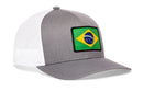 A gray and white mesh Haka Hat Brazil Flag International Trucker Hat by Haka Hat, featuring a rectangular patch of the Brazilian flag on the front.