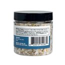 A clear plastic jar of B.T. Leigh’s Garlic & Oregano Finishing Salt and kosher salt flakes, showing the nutrition facts label, ingredients list, and barcode on the back.