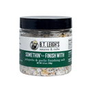 A clear plastic jar of B.T. Leigh’s Jalapeno & Garlic Finishing Salt with a black lid and a label featuring a bearded man logo.