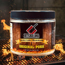 A container of Butcher BBQ Original Pork Injection from Butcher BBQ is perched on a grill, flames blazing underneath for a dramatic effect. The clearly visible label highlights the product in a classic barbecue backdrop, making it ideal for elevating your competition BBQ.