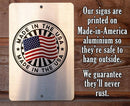 Metal sign with 'Made in the USA' stamp and American flag on a wooden background with text about sign material and durability.