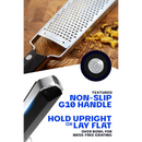 The Dalstrong Professional Coarse Wide Cheese Grater with a textured, non-slip G10 handle is grating ginger. Blue text reads: “Textured Non-Slip G10 Handle” and “Hold Upright or Lay Flat Over Bowl for Mess-Free Grating.”.
