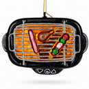 Perfect for cookout lovers, the Barbecue Grill Glass Christmas Ornament by BestPysanky features a sparkly grill with sausage, drumstick, and veggie-meat skewer decorations hanging on a string.
