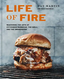 The cover of Life of Fire: Mastering the Arts of Pit-Cooked Barbecue, the Grill, and the Smokehouse: A Cookbook – Hardcover from Books by splitShops features a barbecue sandwich topped with coleslaw on a grill, with the title and authors’ names, Pat Martin and Nick Fauchald, displayed above the image.