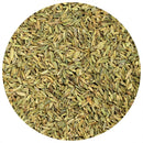 A close-up, top-down view of The Spice Lab Organic Fennel Seeds displays their elongated, ridged shape and greenish-brown color within a circular frame on a white background. These fennel seeds from The Spice Lab are ideal for cooking and are prized for their mild licorice flavor.