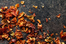 World Spice Ghost Chile Flake by World Spice, with its intense heat reminiscent of Indian cuisine and fiery bhut jolokia ghost chiles, scattered across a dark, scratched surface.