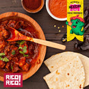A wooden bowl filled with a saucy Mexican meat dish sits on a rustic wooden table, garnished with cilantro and accompanied by tortillas, red sauce, dried chilies, and the bold smokiness of Rico Rico Chipotle Morita Chile Powder Shaker. A colorful "Authentic Mexican Flavor" banner adds extra flair while the Rico Rico logo in the corner promises a genuine taste of Mexican cuisine.
