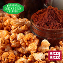 Popcorn coated with a reddish seasoning sits beside a jar of Rico Rico Chipotle Morita Chile Powder Shaker. A green label proclaims "Authentic Mexican Flavor," emphasizing the smoky, savory profile inspired by true Mexican cuisine, while a red label at the bottom displays the brand name "Rico Rico!.