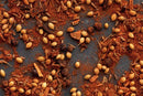 A close-up of World Spice Pakistani Curry spices—including whole coriander seeds, cinnamon pieces, and ground red chili powder from World Spice—essential ingredients scattered on a dark surface for creating an authentic Pakistani curry.