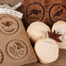 Wooden cookie molds with bird, flower, and animal designs are displayed alongside cookies stamped with matching patterns. On the rustic wooden table, lace adorns the scene along with The Spice Lab Ground Star Anise—a spice from The Spice Lab known for its aromatic, licorice-like flavor.