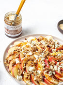 Thinly sliced apples topped with blue cheese, walnuts, and a drizzle of Terrapin Ridge Farms Apple Maple Bacon Jam Quart, served with a jar of the jam (by Terrapin Ridge Farms) and a spoon on the side.