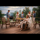 Friends gather on a deck with food and drinks, as a woman relaxes in the Kanyon Living Adirondack Poly Glider Swivel Chair (Black & Deluxe Antique Mahogany). Others mingle by the grill under string lights, with trees and water beyond.
