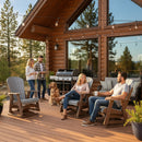 Four adults and a golden retriever enjoy a sunny day on the cabin deck—two relax in Kanyon Living Adirondack Poly Glider Swivel Chairs (Light Grey & Weathered Wood) while others grill amid pine trees and eco-friendly furniture under string lights.