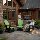 A man grills on a patio with stone paving and string lights. A woman relaxes with a drink in a Kanyon Living Adirondack Poly Glider Swivel Chair in Lime Green & Black as their golden retriever lounges nearby, enjoying the inviting Kanyon Living setting.