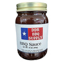 DDR BBQ Supply BBQ Sauce – 16 oz has a smoky-sweet flavor and Texas flag label with red and blue text. Ideal for grilling, this sauce is made by DDR BBQ Supply, with the supplier’s address in Garfield, Arkansas on the label.