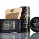 DDR BBQ Supply Immaculate Beard grooming kit with Daybreak wash bar, oil, balm, and wooden comb on reflective surface.
