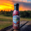 DDR BBQ Supply Big Wick's Blueberry Jalapeño Glaze bottle with a vibrant sunset background.
