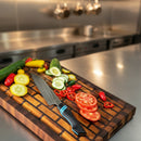 DDR BBQ Supply Spaceman Knives Calypso Kiritsuke on a wooden board with sliced vegetables in a professional kitchen